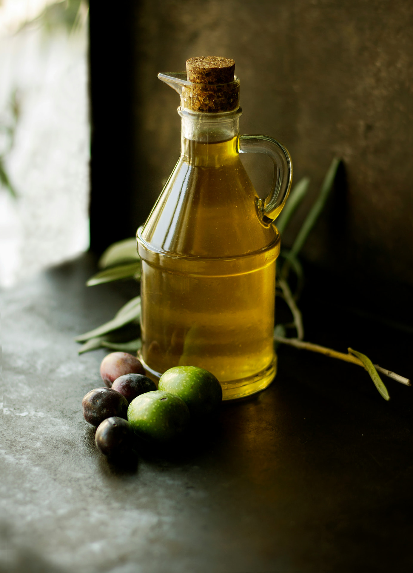Carafe d'huile d'olive grecque avec olives fraîches